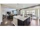 Modern kitchen island with granite countertops, pendant lighting, and open view to the living room at 12631 Glencoe St, Thornton, CO 80241