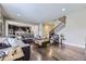 Open-concept living room with hardwood floors, and seamless flow to the kitchen and staircase at 12631 Glencoe St, Thornton, CO 80241