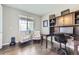 Home office with hardwood floors, built-in shelving, and large window for ample natural light at 12631 Glencoe St, Thornton, CO 80241