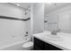 Clean bathroom featuring a shower-tub combo, white tile and a modern black vanity at 4545 S Monaco St # 328, Denver, CO 80237