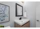 Bathroom with light blue walls, and wood vanity with a white countertop and modern black faucet at 4545 S Monaco St # 328, Denver, CO 80237