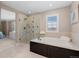 Elegant bathroom featuring a glass shower, soaking tub and stylish fixtures at 4545 S Monaco St # 328, Denver, CO 80237