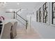 Hallway featuring a staircase with white risers, wood handrail and decorative wall art at 4545 S Monaco St # 328, Denver, CO 80237