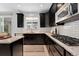 Kitchen featuring black cabinets, stainless steel appliances, and granite countertops at 4545 S Monaco St # 328, Denver, CO 80237