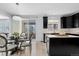 Eat-in kitchen features an island, black cabinets, stainless appliances, and sliding door to the backyard at 4545 S Monaco St # 328, Denver, CO 80237