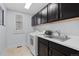 Laundry room featuring tile floors, modern appliances, sink, and dark wood cabinets at 4545 S Monaco St # 328, Denver, CO 80237