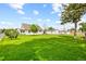 Expansive backyard with lush lawn, mature trees, and outbuildings at 276 N 5Th Ave, Brighton, CO 80601