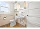 This bathroom features a white toilet and sink with a window for natural light at 276 N 5Th Ave, Brighton, CO 80601