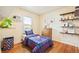 A cozy bedroom with hardwood floors, a window, and decorative shelving at 276 N 5Th Ave, Brighton, CO 80601