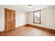 An empty bedroom with hardwood floors, natural wood trim, and a bright window at 276 N 5Th Ave, Brighton, CO 80601