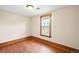 This bedroom features wood floors, a window with wood trim, and a modern ceiling light at 276 N 5Th Ave, Brighton, CO 80601