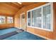 Enclosed sunroom with wood paneling, natural light, and carpeted floor at 276 N 5Th Ave, Brighton, CO 80601