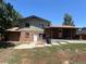 View of the home's back exterior, featuring brick, siding, and access to the backyard at 12252 Elmendorf Pl, Denver, CO 80239