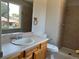 Bathroom features a vanity with a white sink, toilet and walk-in shower with tiled walls at 12252 Elmendorf Pl, Denver, CO 80239