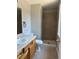 Neutral bathroom featuring a vanity with sink, toilet, and walk-in shower with tiled walls at 12252 Elmendorf Pl, Denver, CO 80239