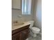 Outdated bathroom features a sink, toilet and window for natural light at 12252 Elmendorf Pl, Denver, CO 80239