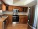 Kitchen featuring stainless steel appliances, wood cabinets, and laminate countertops at 12252 Elmendorf Pl, Denver, CO 80239