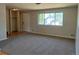 View of a spacious carpeted living room with a window, door, and closet at 12252 Elmendorf Pl, Denver, CO 80239