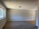 Spacious living room with large window, neutral paint, and a mix of carpet and wood flooring at 12252 Elmendorf Pl, Denver, CO 80239