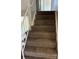 Carpeted staircase with white railings leads to the upper level of the home at 12252 Elmendorf Pl, Denver, CO 80239
