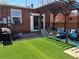 Cozy backyard featuring a pergola, artificial grass, and outdoor seating, perfect for entertaining and relaxation at 1847 W 41St Ave, Denver, CO 80211