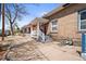 Inviting brick home featuring a classic front porch and a well-kept yard on a tree-lined street at 1847 W 41St Ave, Denver, CO 80211