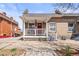 Charming brick home featuring a red front door and covered porch with white railings at 1847 W 41St Ave, Denver, CO 80211