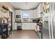Well-lit kitchen with white cabinetry, stainless appliances, and functional layout at 1847 W 41St Ave, Denver, CO 80211