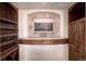 Basement nook featuring custom wood cabinets, a wine rack, and a stone tile display at 2208 Stevens Ct, Castle Rock, CO 80109