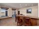 Finished basement featuring a full wet bar with leather barstools, stone accents, and outdoor access at 2208 Stevens Ct, Castle Rock, CO 80109