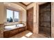 Bright bathroom with a soaking tub under a large window, a tiled shower and a wood door at 2208 Stevens Ct, Castle Rock, CO 80109