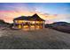 A large hillside home with a spacious deck, stone pillars, and lots of natural light at dusk at 2208 Stevens Ct, Castle Rock, CO 80109