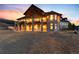 The rear of the luxury home is elevated with a stone porch and outdoor seating area at 2208 Stevens Ct, Castle Rock, CO 80109