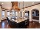An open-concept kitchen includes a granite island with seating and top-of-the-line appliances beneath custom hood at 2208 Stevens Ct, Castle Rock, CO 80109