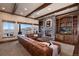 Spacious living room boasts a stone fireplace, built-in shelves, wooden beams, and great outdoor views at 2208 Stevens Ct, Castle Rock, CO 80109