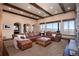 Open-concept living room features exposed beams, large windows, and an oversized leather couch at 2208 Stevens Ct, Castle Rock, CO 80109
