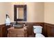 Stylish powder room with unique stone sink, wood paneling and decorative mirror at 2208 Stevens Ct, Castle Rock, CO 80109