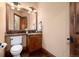 Well lit powder room features wood vanity and mirror with granite countertops at 2208 Stevens Ct, Castle Rock, CO 80109