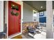 Cozy front porch with stone accents, a red door with wreath, and comfortable seating at 17955 Sky Pilot Ave, Parker, CO 80134