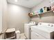 A functional laundry room featuring a washer, dryer, storage, and shelving at 17955 Sky Pilot Ave, Parker, CO 80134