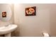 Powder room featuring a pedestal sink, neutral walls, and decorative artwork at 17955 Sky Pilot Ave, Parker, CO 80134