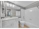 Bright bathroom featuring a tub/shower combo with white tile and a vanity with a large mirror at 12023 E Harvard Ave # 203, Aurora, CO 80014