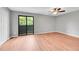 This bedroom has wood floors, neutral paint, and a sliding glass door to a balcony at 12023 E Harvard Ave # 203, Aurora, CO 80014