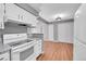 Updated kitchen with white cabinets, granite countertops, and modern appliances and adjacent dining area at 12023 E Harvard Ave # 203, Aurora, CO 80014
