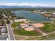 Aerial view of a recreational park including a baseball field, community lake, and mountain views in the background at 3780 W 66Th Ave, Arvada, CO 80003
