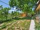 Private backyard featuring a green lawn, mature trees, a storage shed, and garden beds at 3780 W 66Th Ave, Arvada, CO 80003