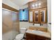 Bathroom features a shower with glass door, vanity and wood framed mirror at 3780 W 66Th Ave, Arvada, CO 80003