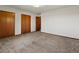 Spacious carpeted bedroom featuring a standard ceiling light and multiple wood paneled closets at 3780 W 66Th Ave, Arvada, CO 80003