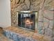 Stone fireplace featuring a glass-enclosed firebox with a stone hearth and brass trim at 3780 W 66Th Ave, Arvada, CO 80003