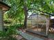 Backyard featuring a greenhouse, garden beds, mature trees, and lush greenery at 3780 W 66Th Ave, Arvada, CO 80003